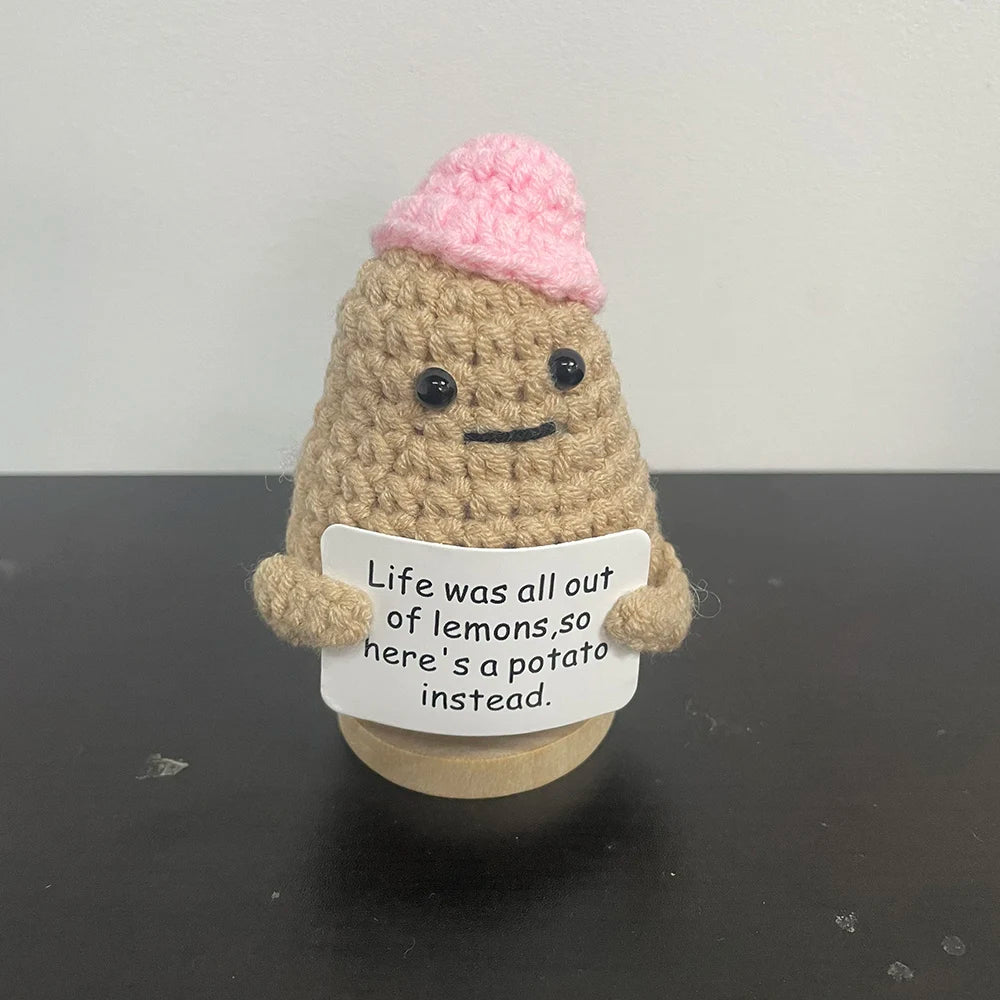 Handmade crochet potato plush doll with pink hat, holding a sign that says "Life was all out of lemons, so hereβs a potato instead